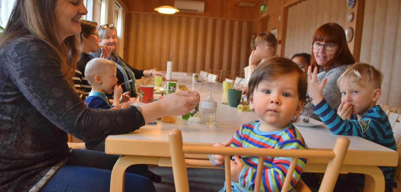 Bild på barn och mammor runt bordet i Bergö församlingshem.