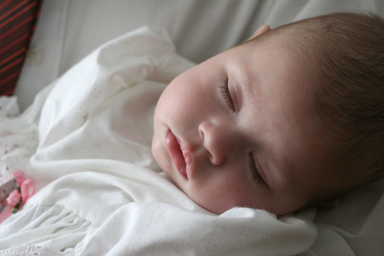 Bild på sovande baby i dopkolt.